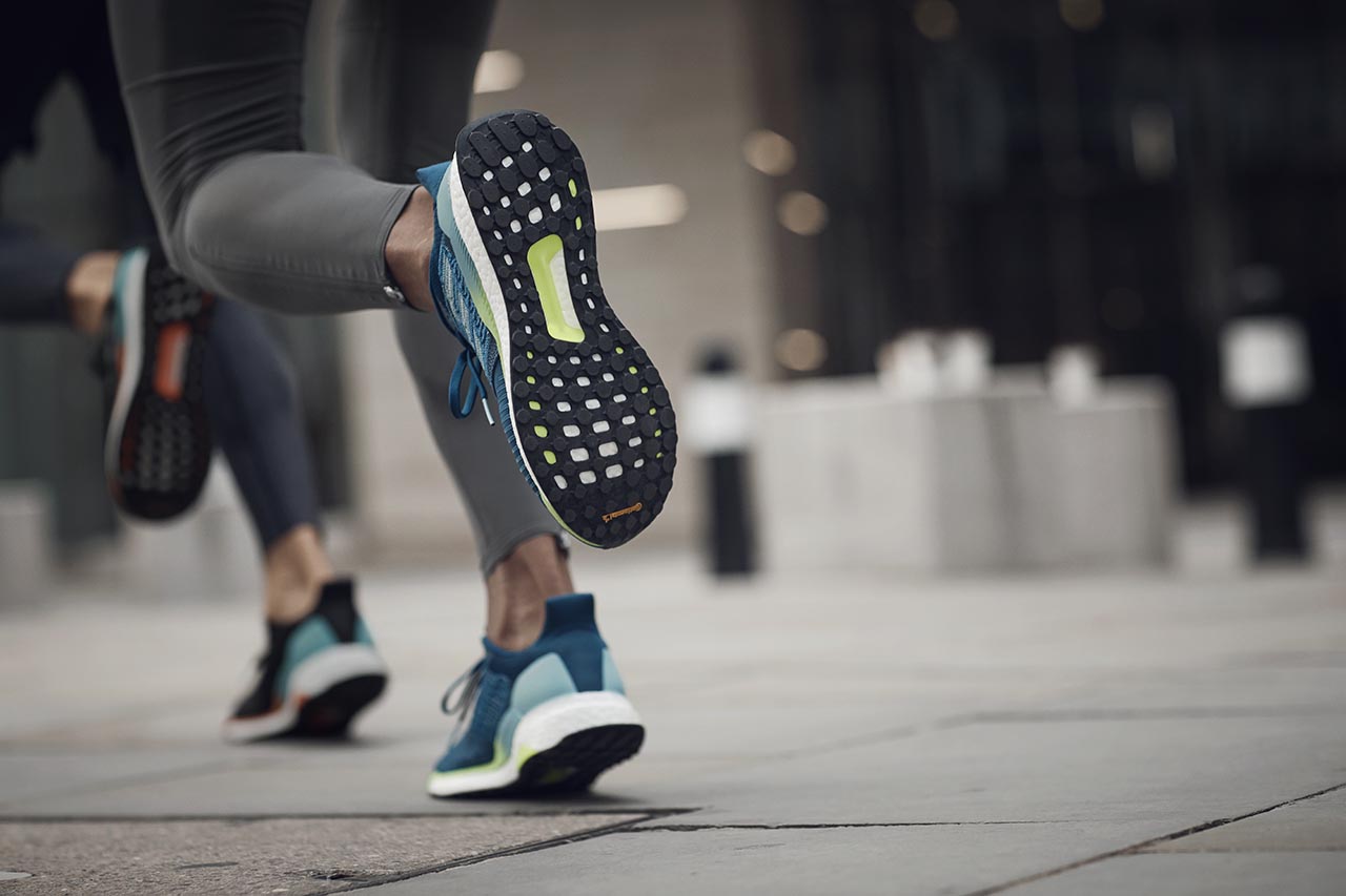 Woman running with Adidas Solarboost sports shoe.