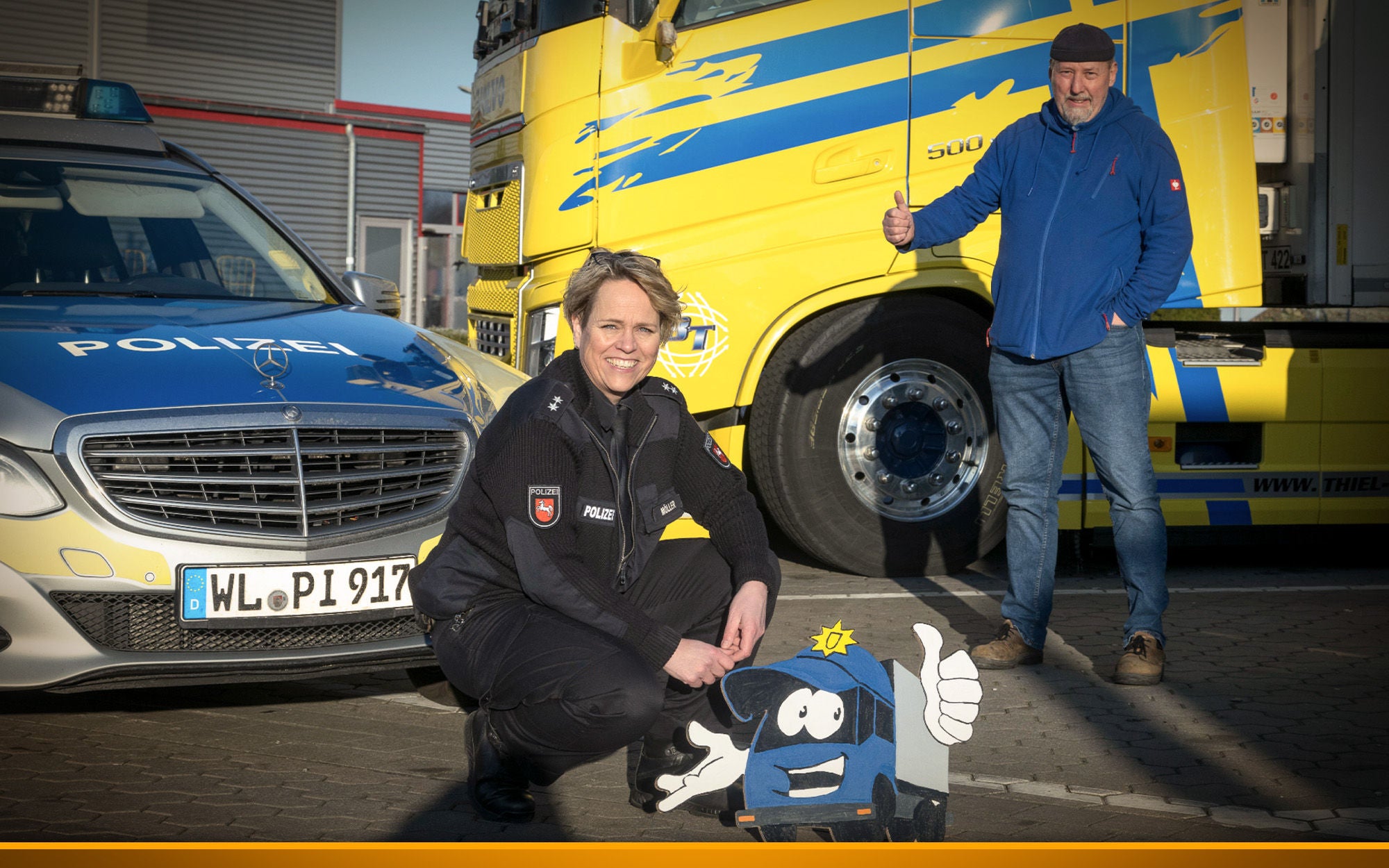 police officer next to a police car with a trucker in the background