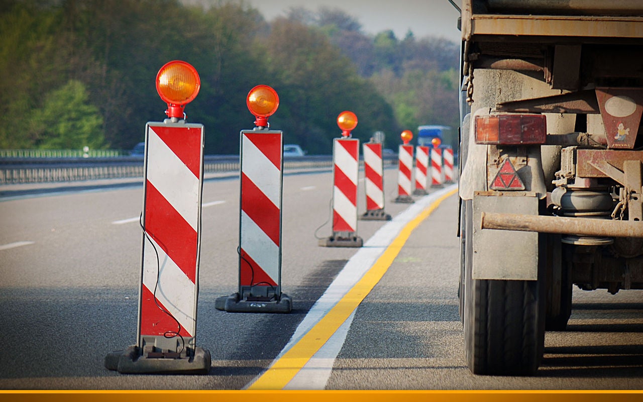 truck standing on a highway next to a closed road