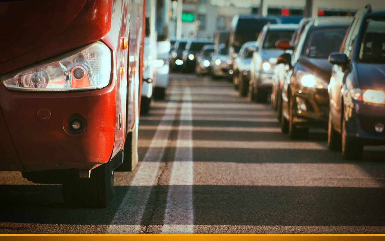 bus standing between cars in a traffic jam