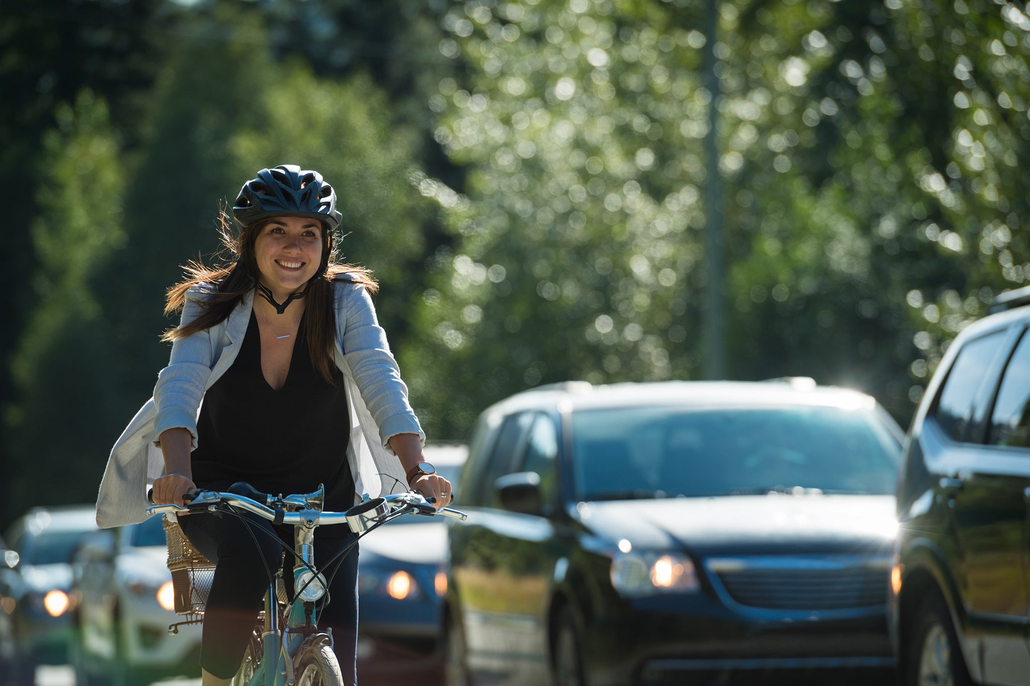 Eine Frau überholt den Verkehr auf ihrem Fahrrad auf einem Radweg.