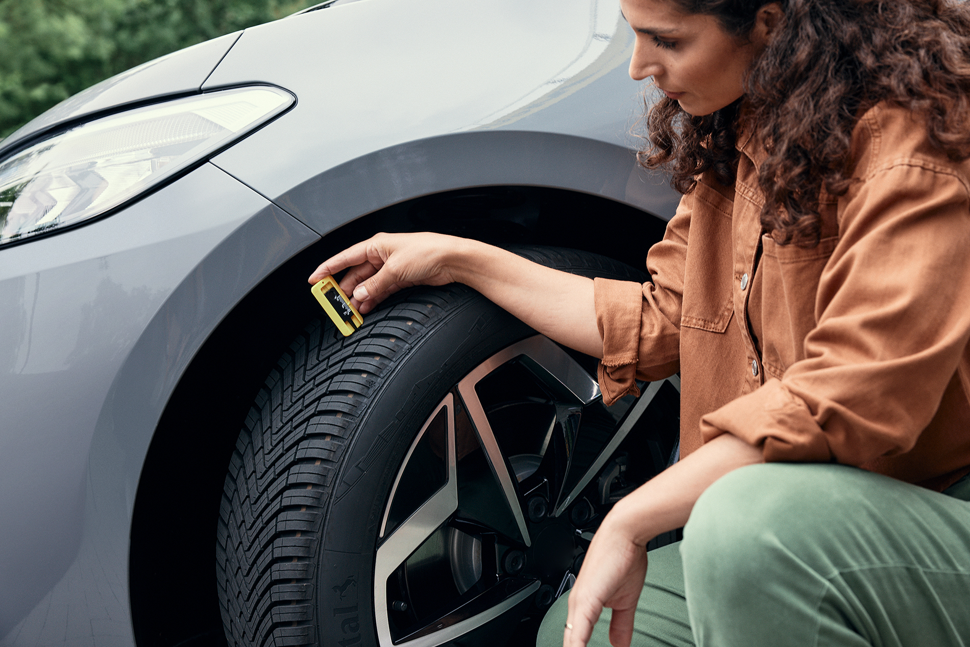 Tread depth AS Woman checking her car´s tire tread depth