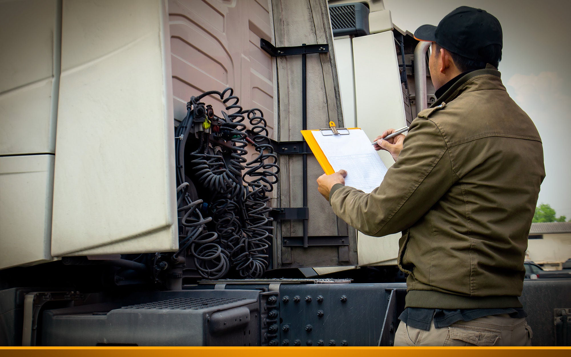 Truck driver holding clipboard inspecting safety daily check a truck