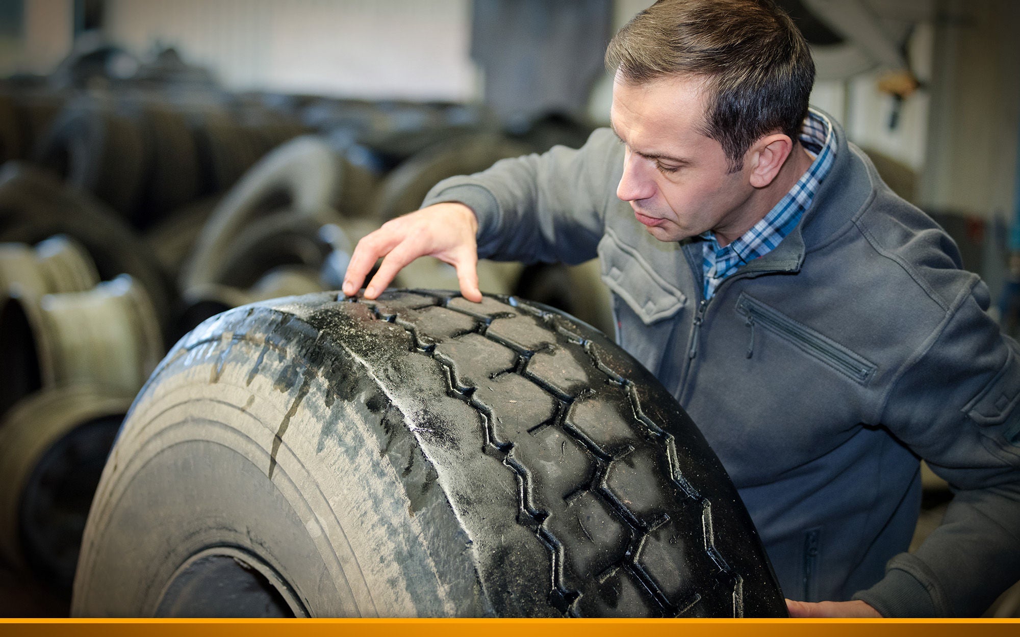 mechanic checking tread on a truck tires