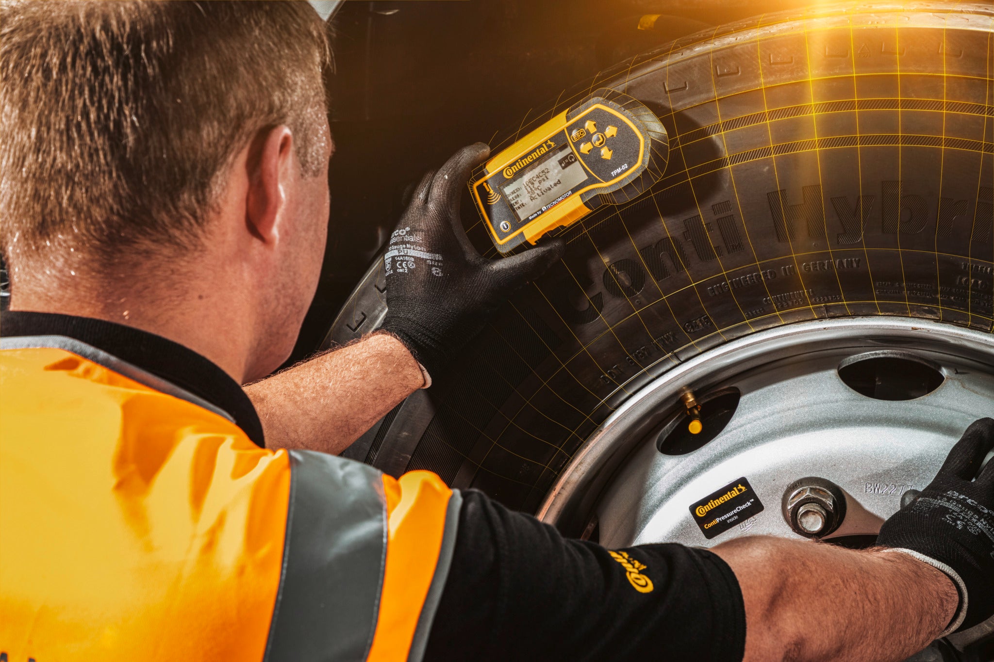 A man from the Conti360 Breakdown service inspects a truck tire