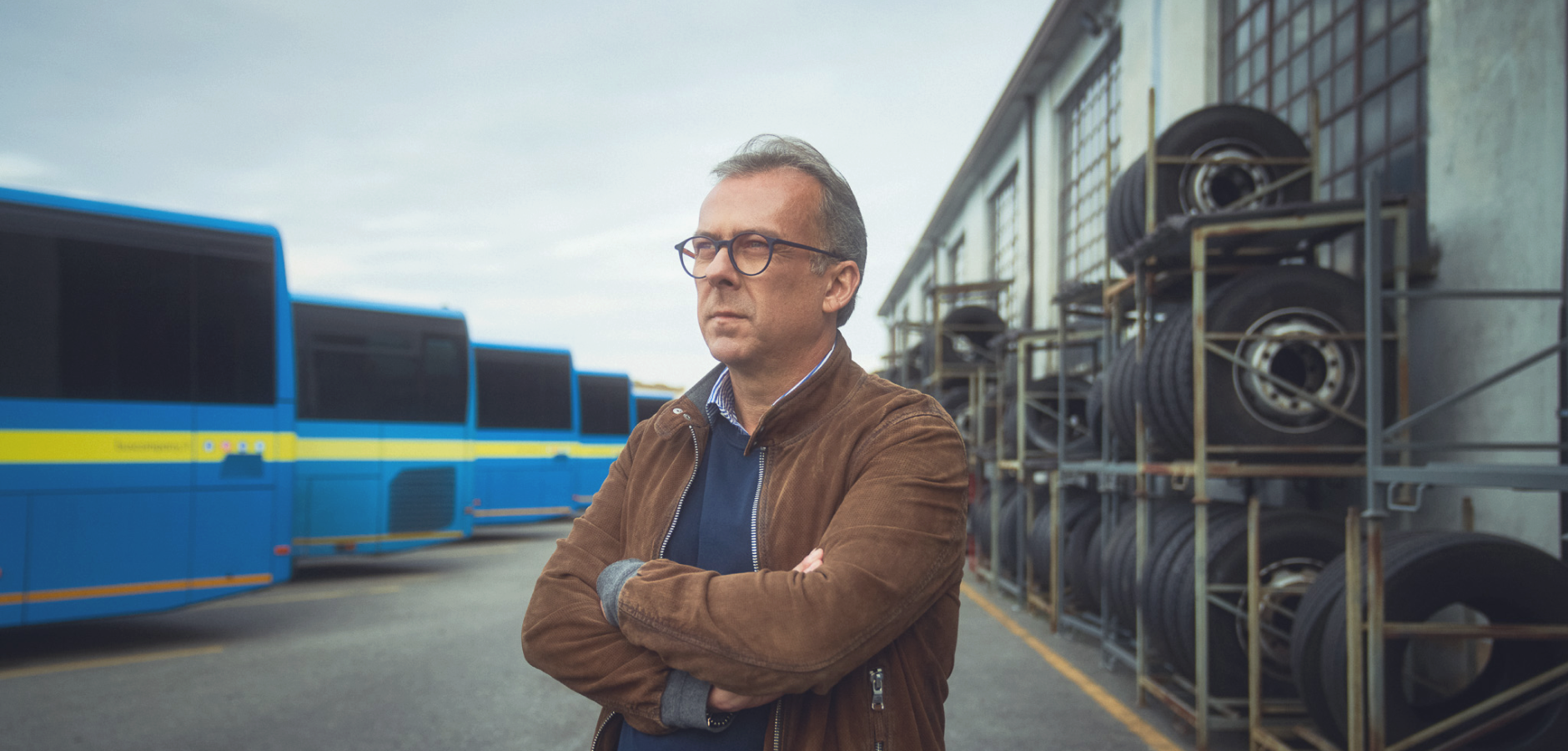Mann mit verschränkten Armen vor Bussen
