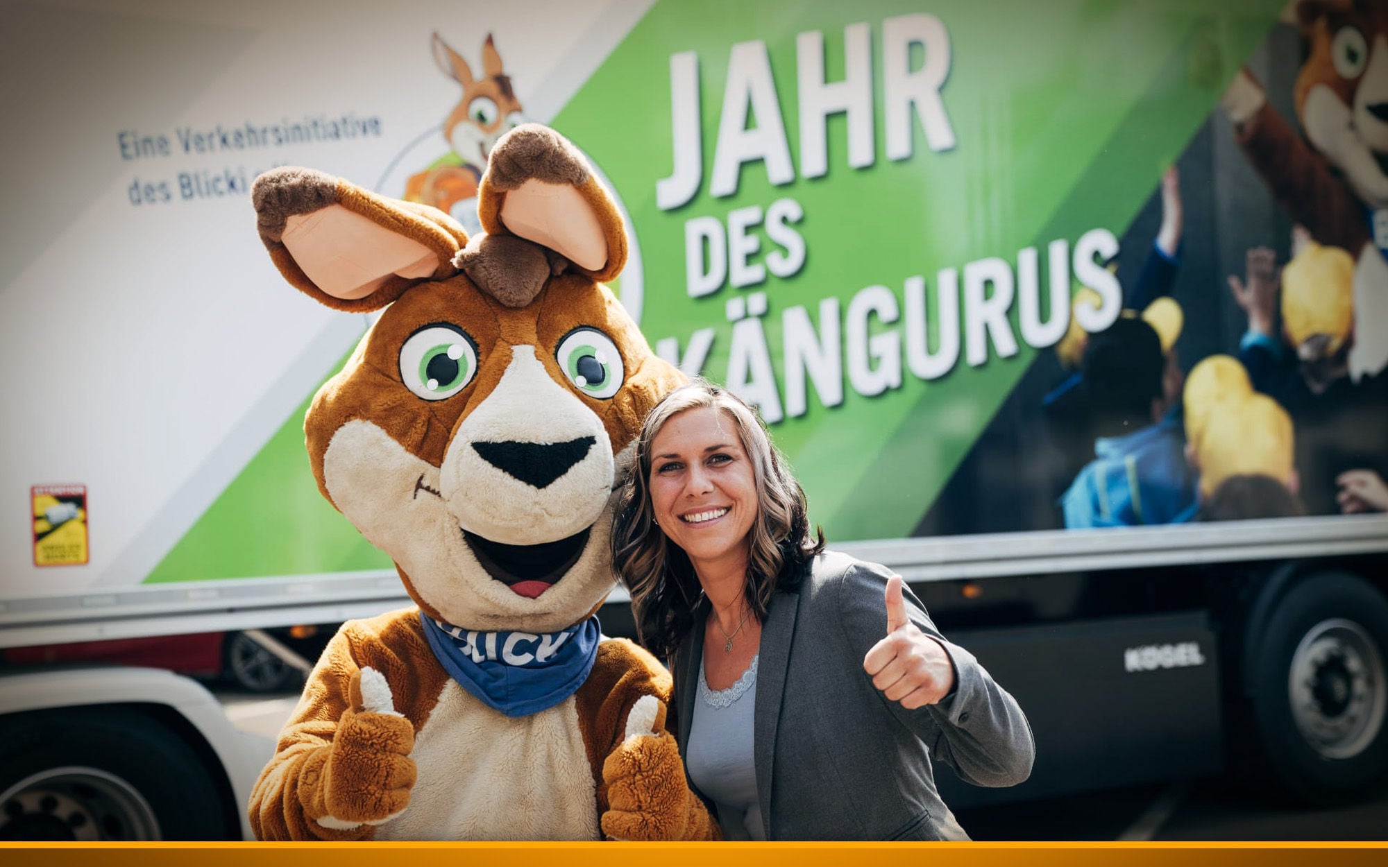 Female trucker with a mascot in front of a truck