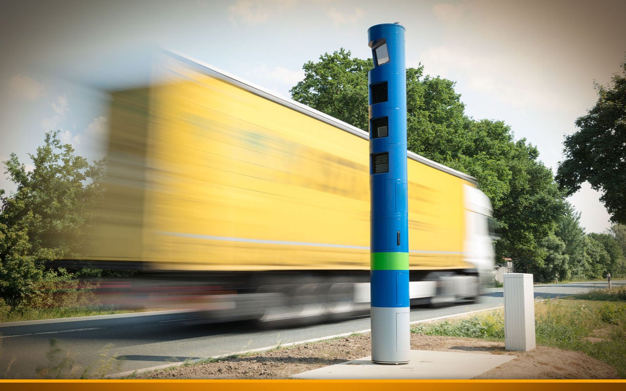 Truck drives past a blue toll booth