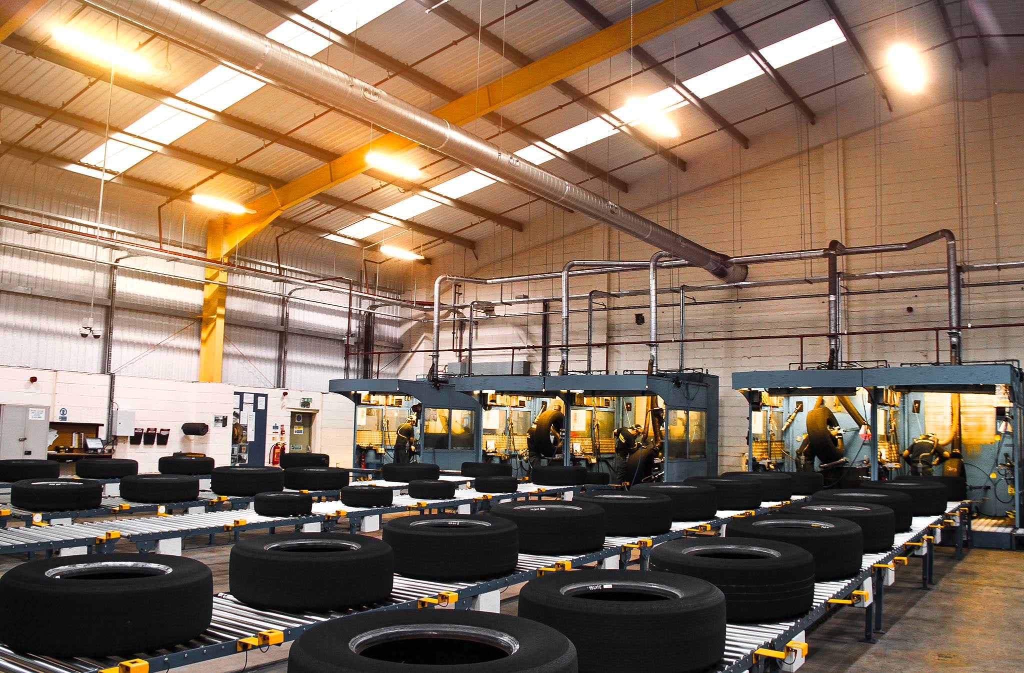 a lot of tires lying on a conveyor belt in a hall