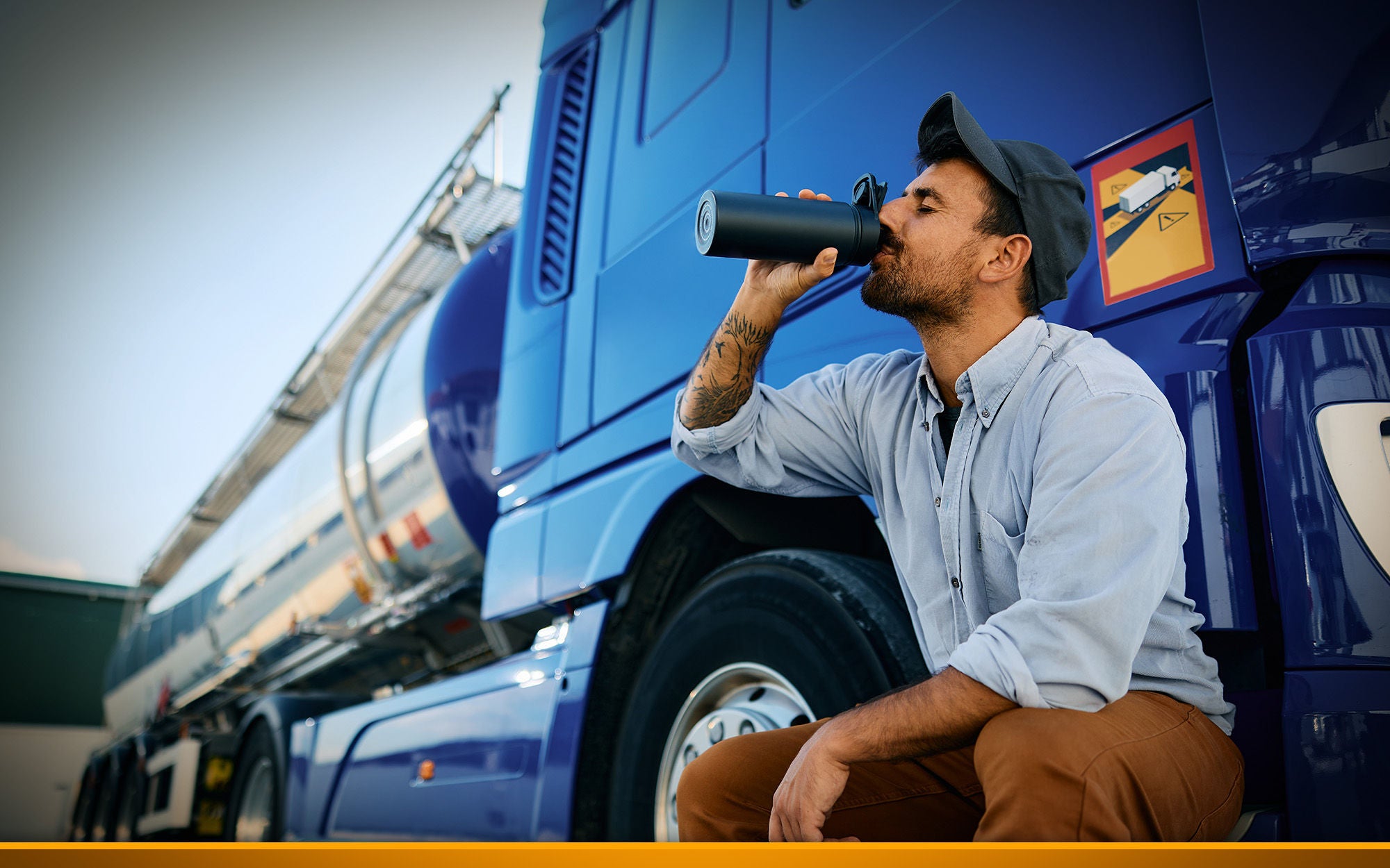 Truck driver drinking water from bottle on parking lot