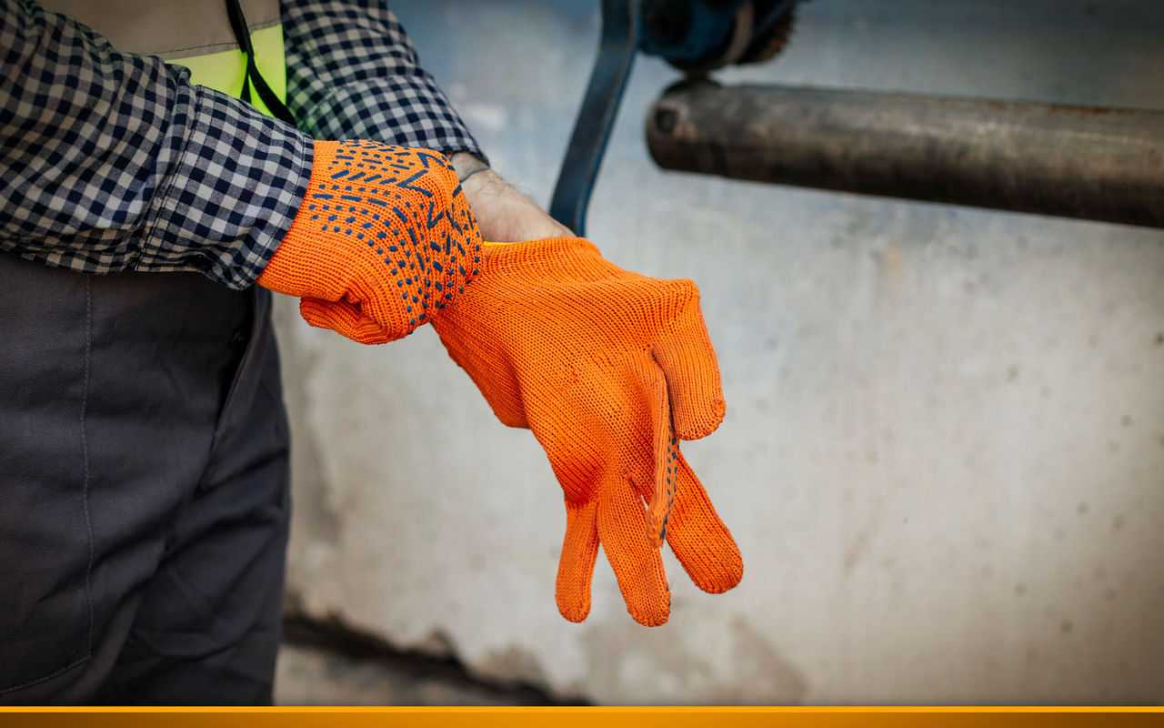 Worker putting on protective gloves