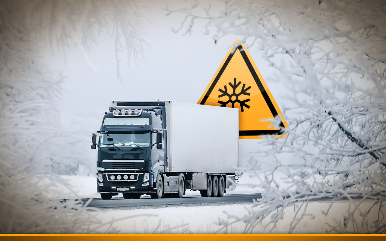 winter road transportation truck with a snow attention sign in the background