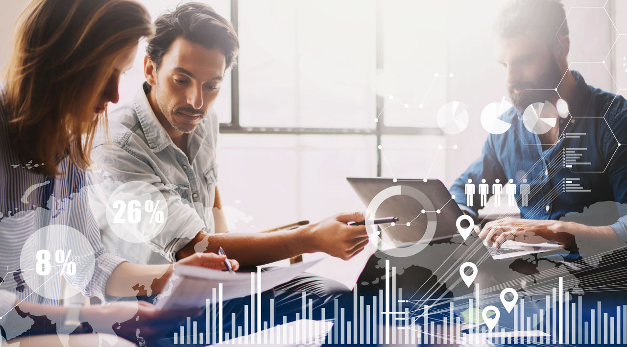 Concept of digital diagram,graph interfaces,virtual screen,connections icon on blurred background.Group of three young coworkers working together at modern coworking studio