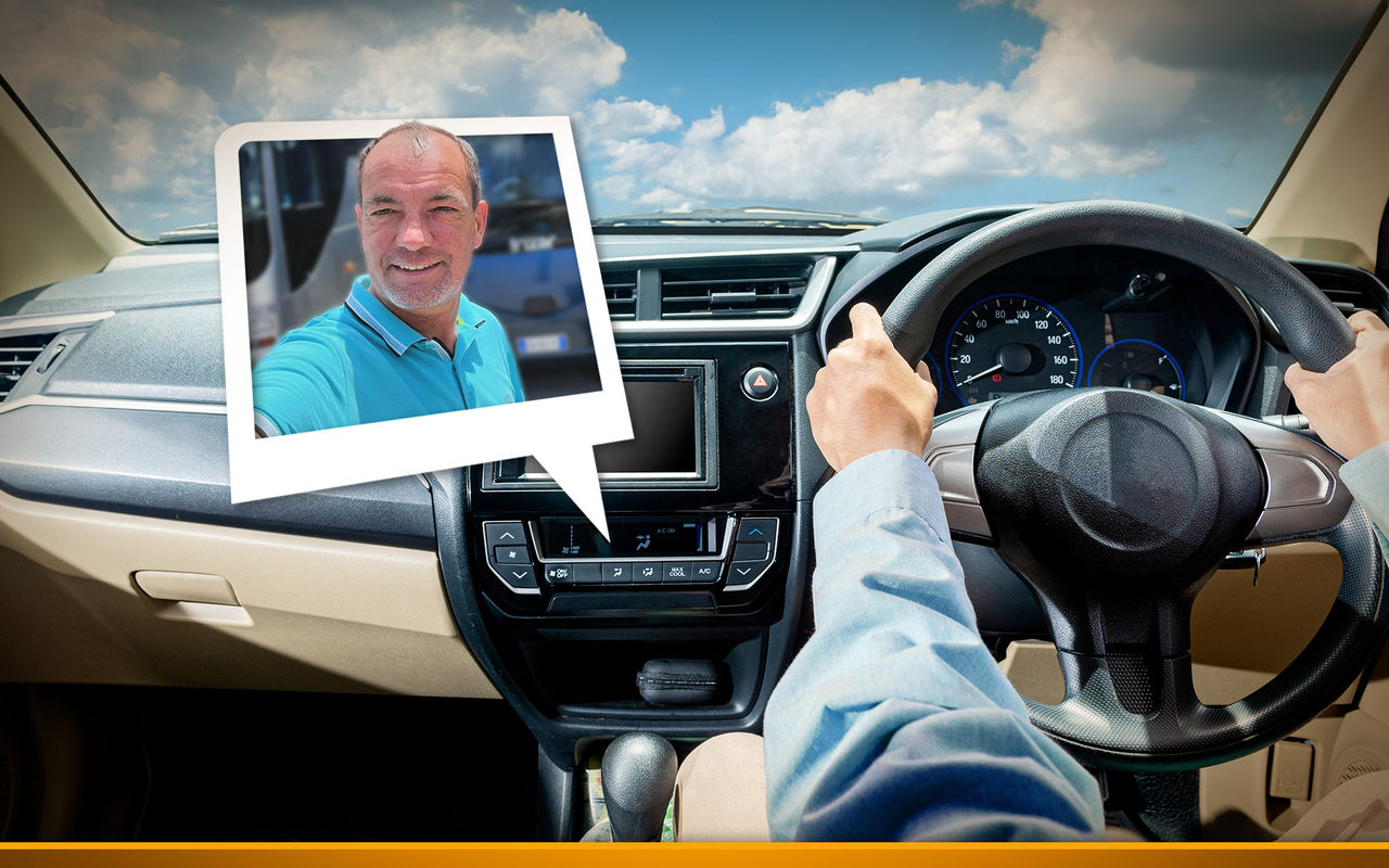 Man with his hands on the steering wheel. Sitting on the right.