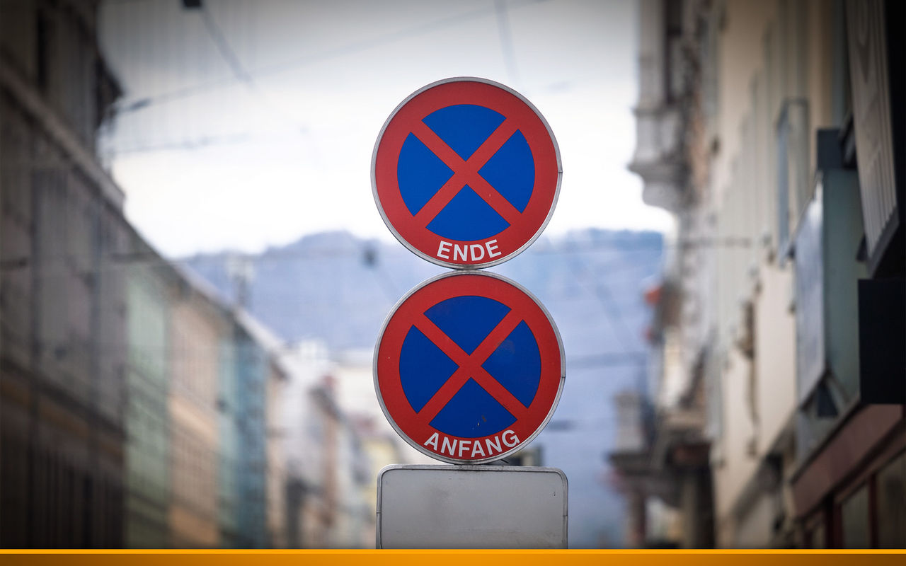 Stacked round No Stopping signs marked Anfang and Ende (start and end in german) indicate stopping ban on street in Graz, Austria. The red and blue European ...