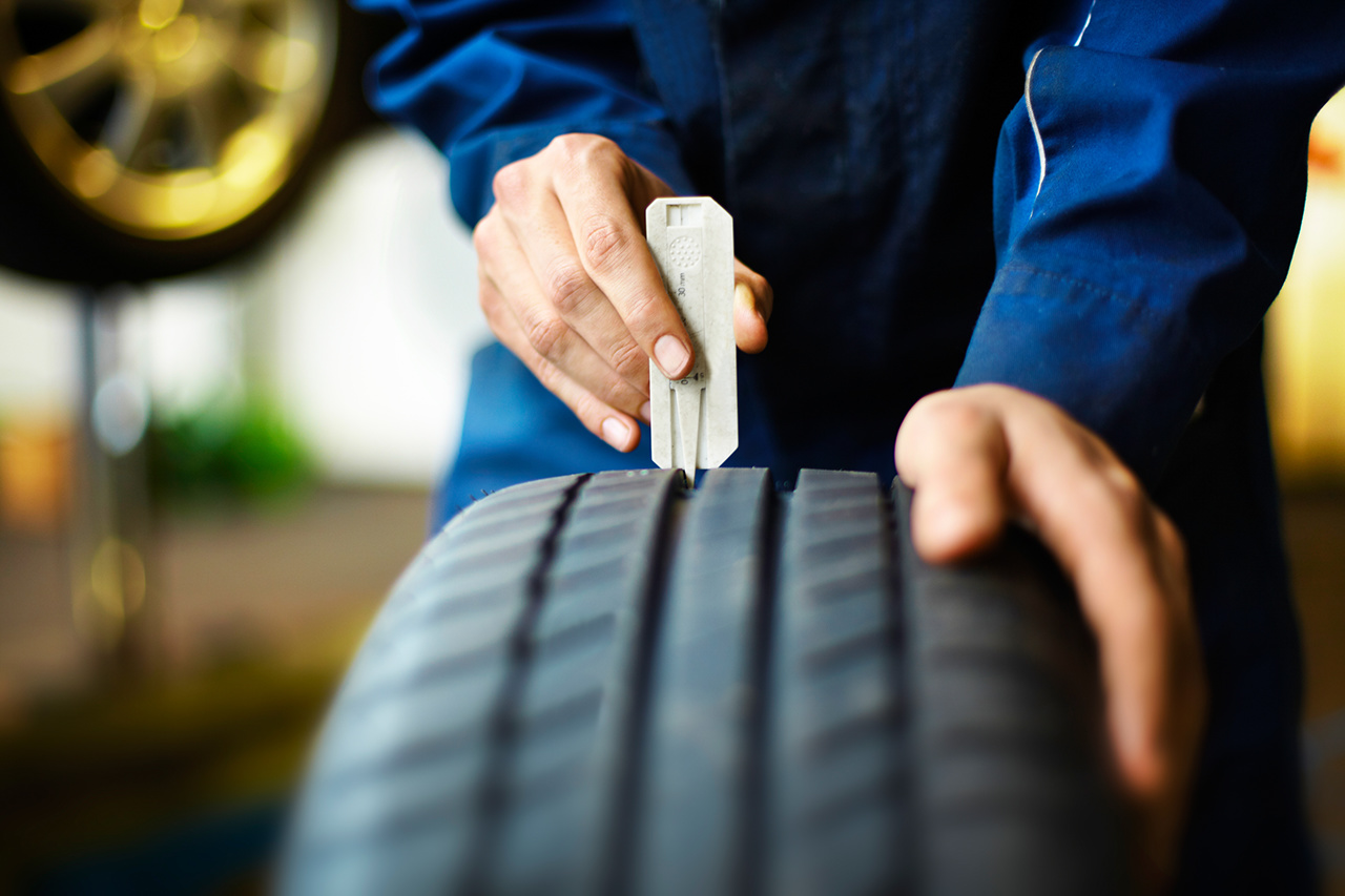Mechaniker überprüft die Reifenprofiltiefe